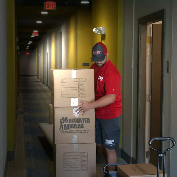 Motivated Movers worker carefully checks an employee inventory, ensuring accurate and organized relocation services.